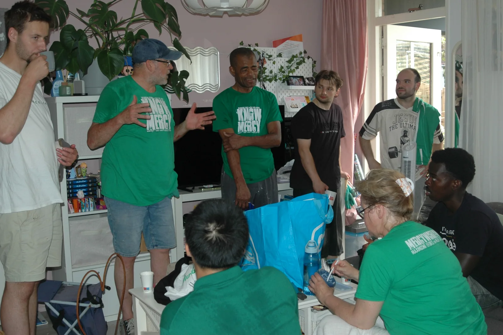 People in MercyWorldwide shirts talking together indoors